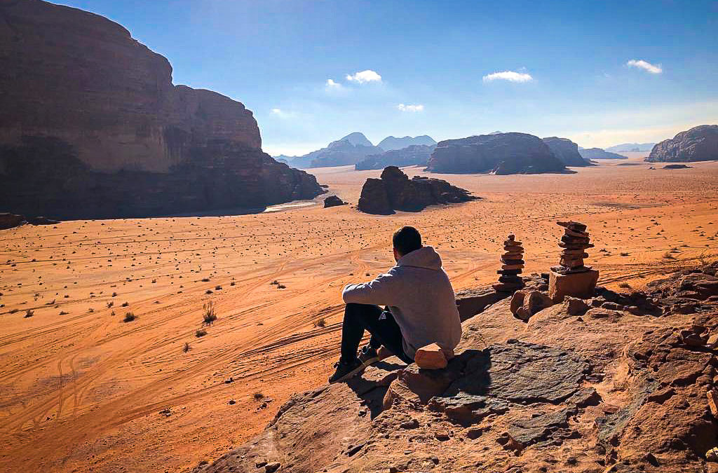 Man sitting in Wadi Rum overlooking the desert in Jordan