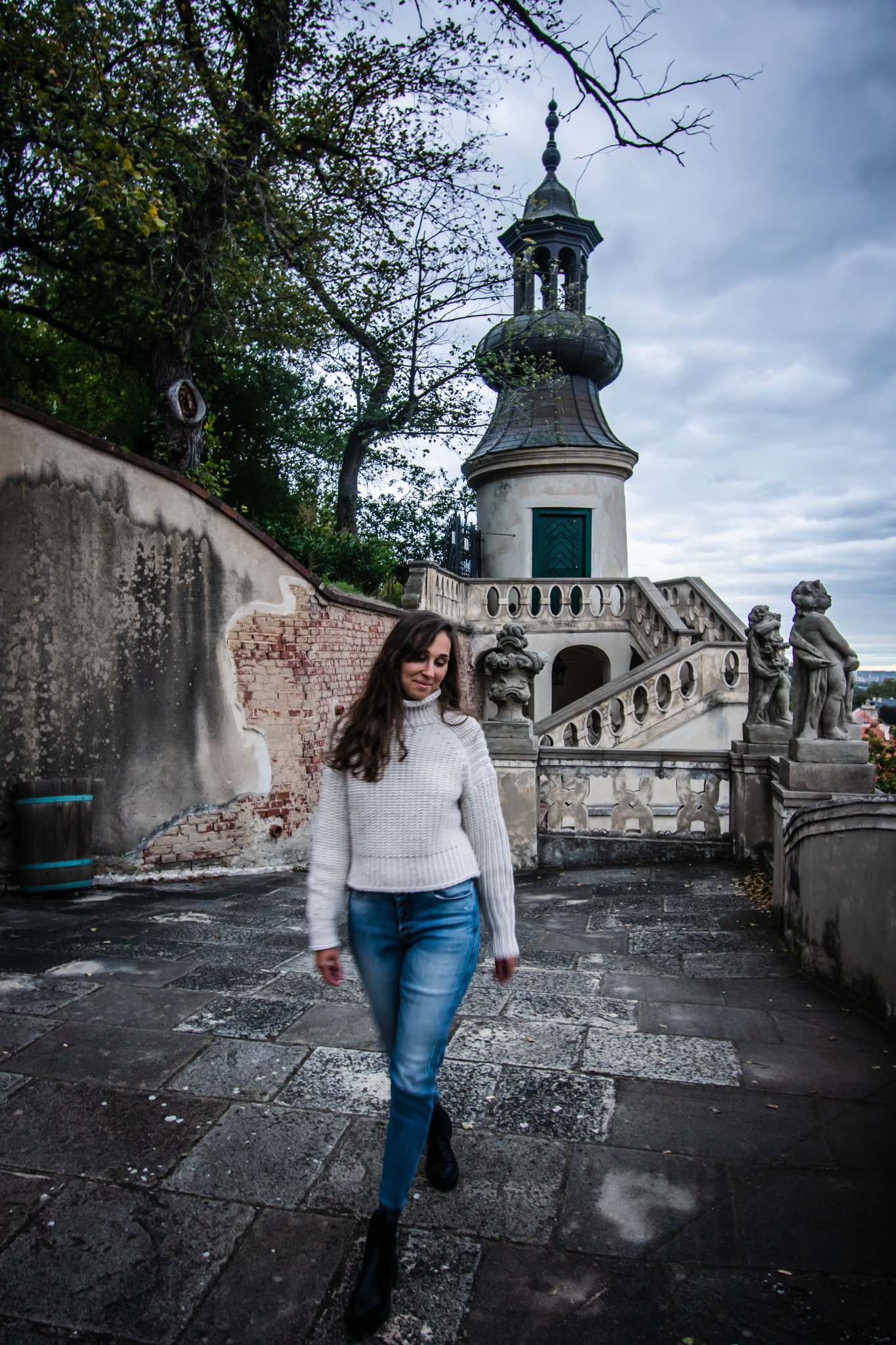 Woman walking in front of an old Tower in Prague