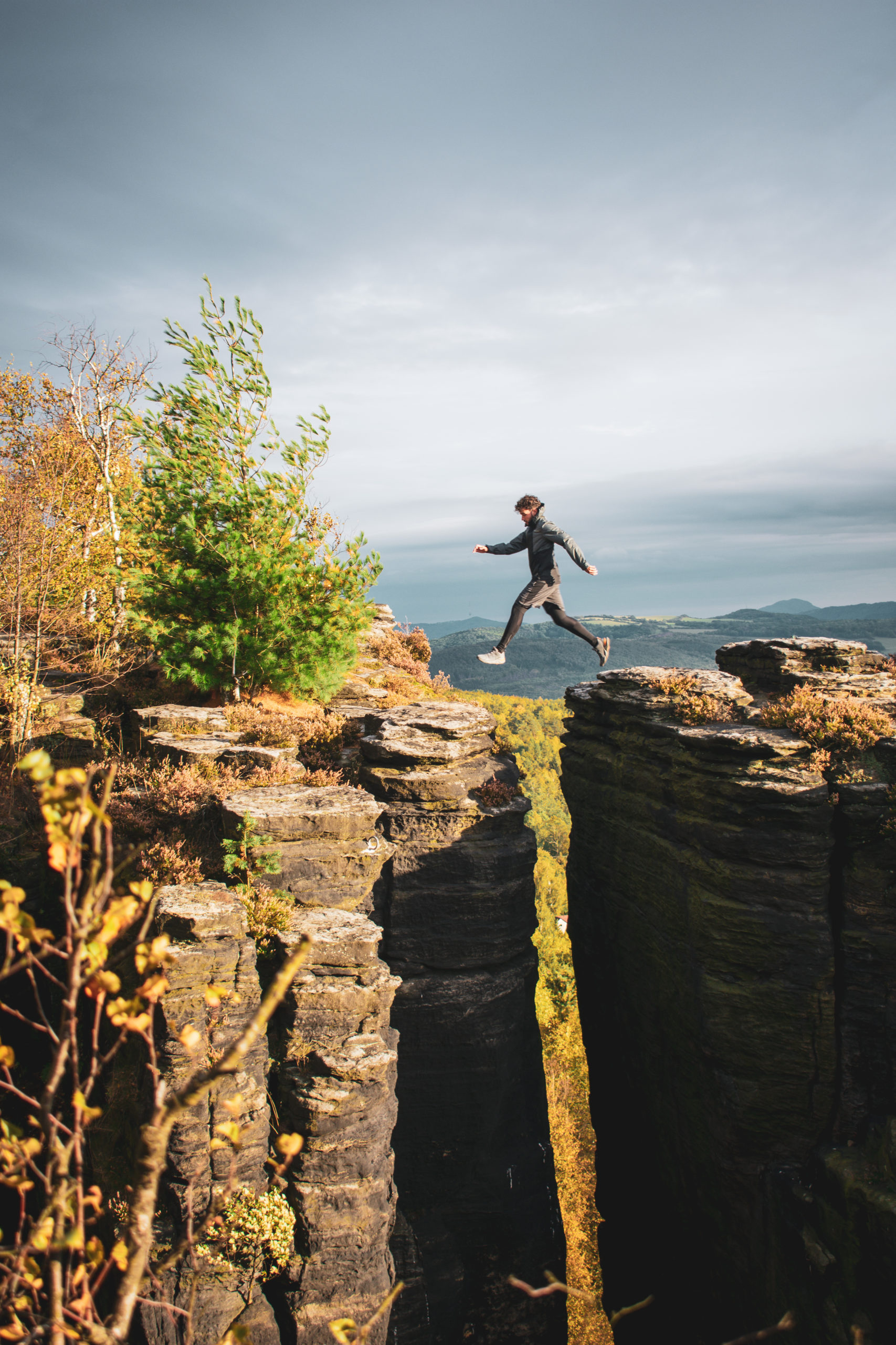 Man jumping between two rocks in Bohemian Switzerland in Czech Republic