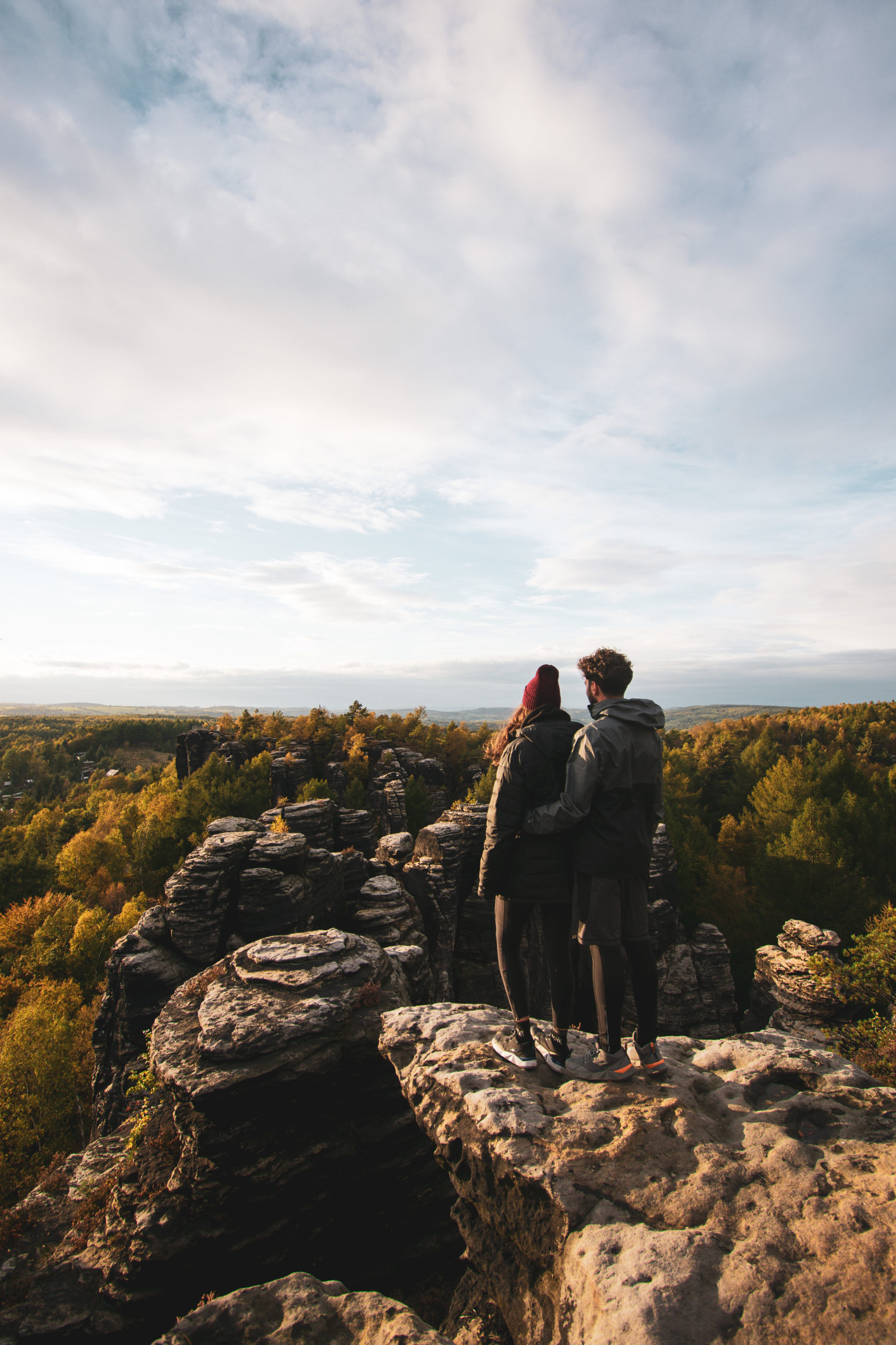 Couple standing above a forest in Bohemian Switzerland in Czech Republic