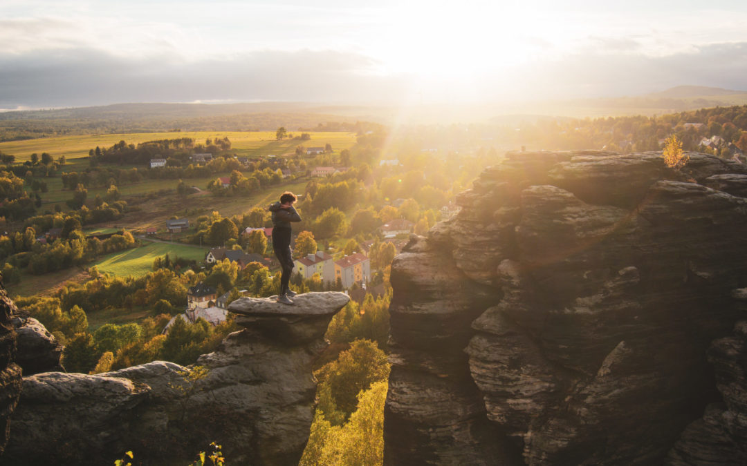 Man standing up on a rock at sunset in Bohemian Switzerland national park in Czech Republic