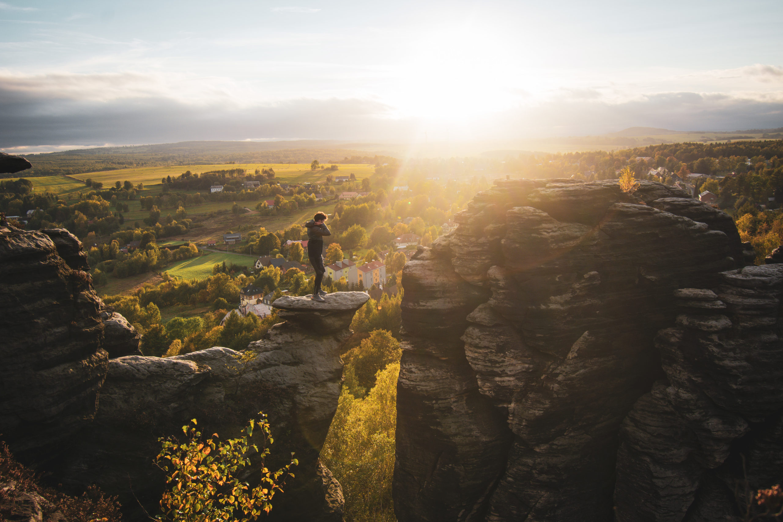 Man standing up on a rock at sunset in Bohemian Switzerland national park in Czech Republic