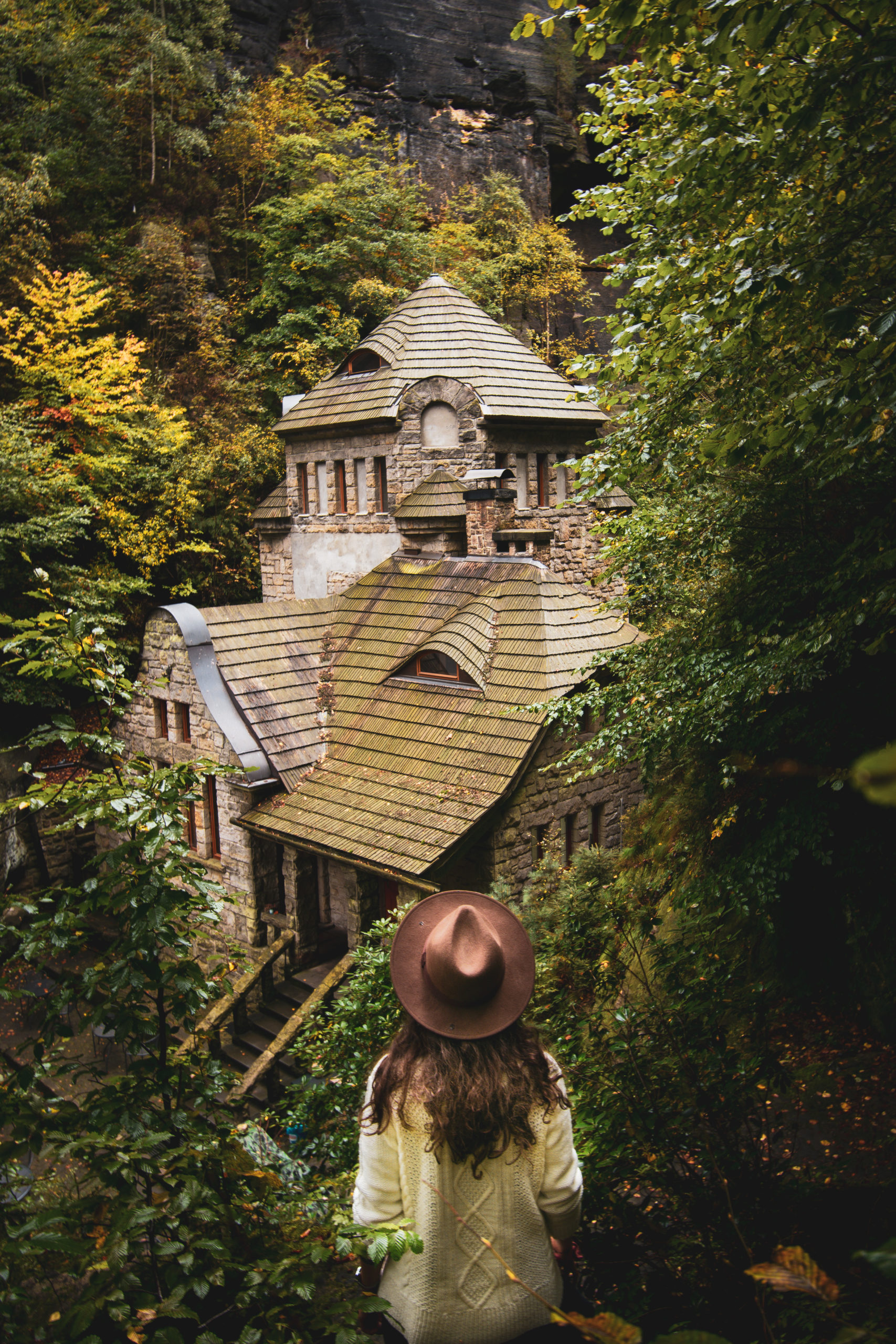Woman standing in front of an old haunted house in Czech Republic