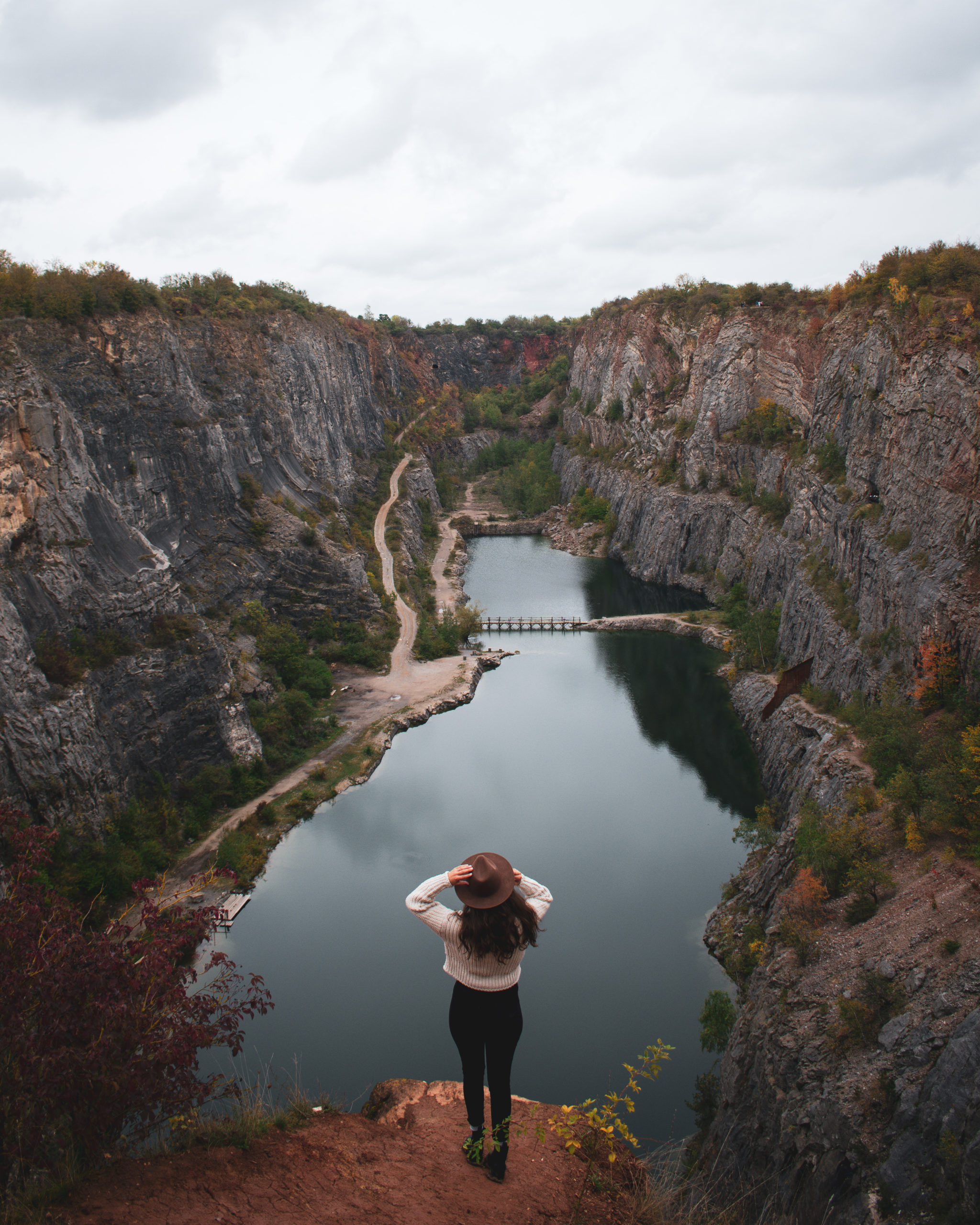 Woman standing up in front of a canyon filled with water in Velka America in Czech Republic