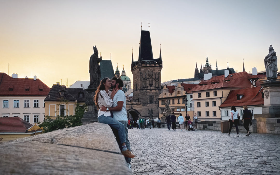Couple hugging on the Charles bridge in Prague at sunset