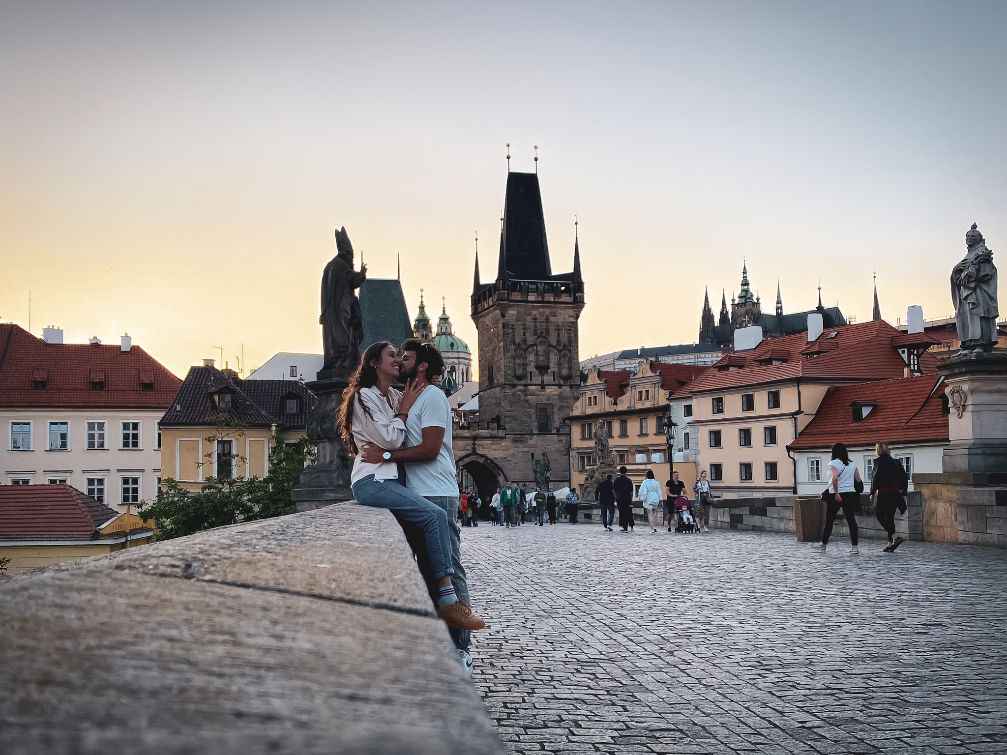 Couple hugging on the Charles bridge in Prague at sunset