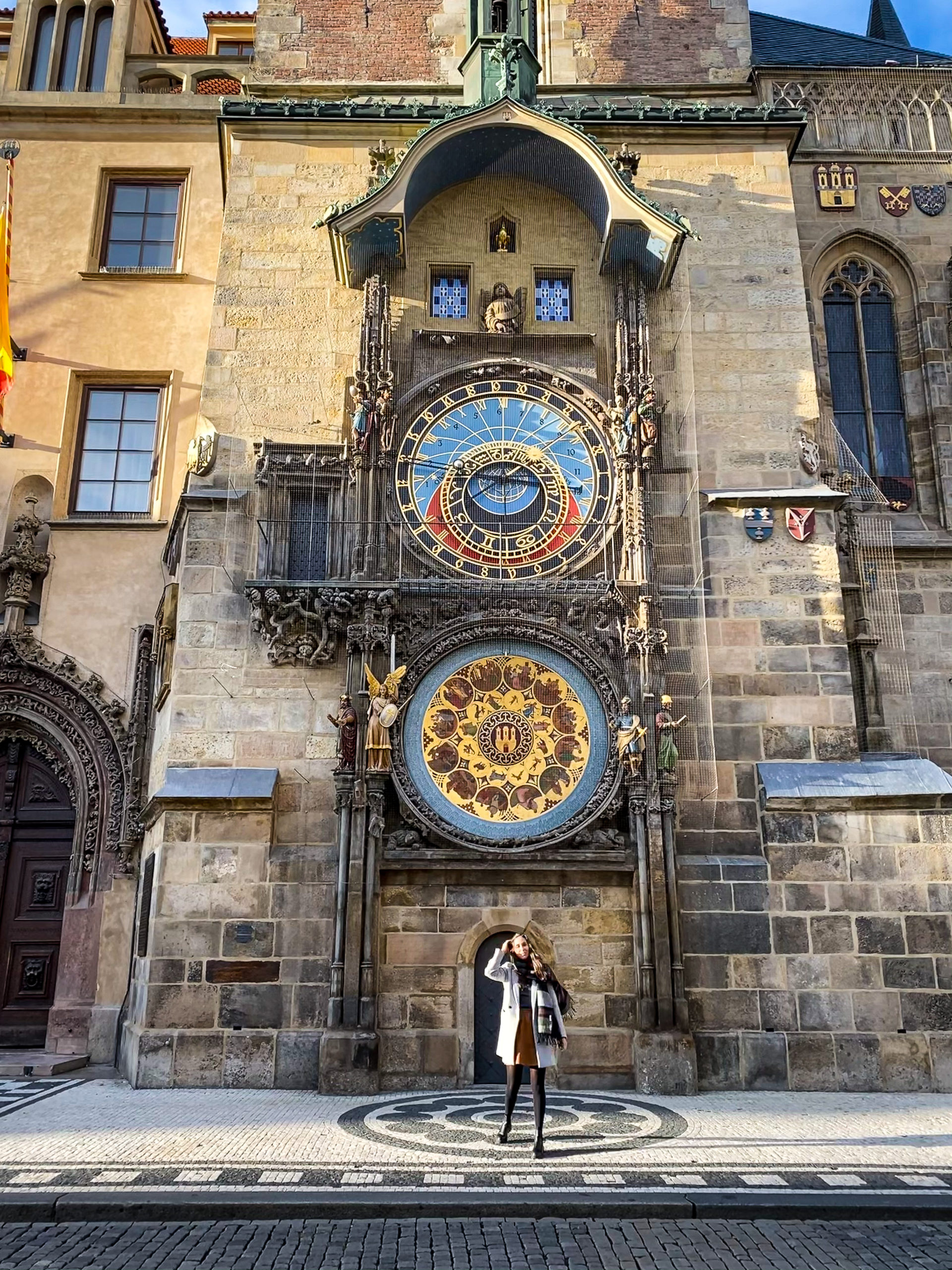 Woman walking in front of the astronomical clock in Prague 