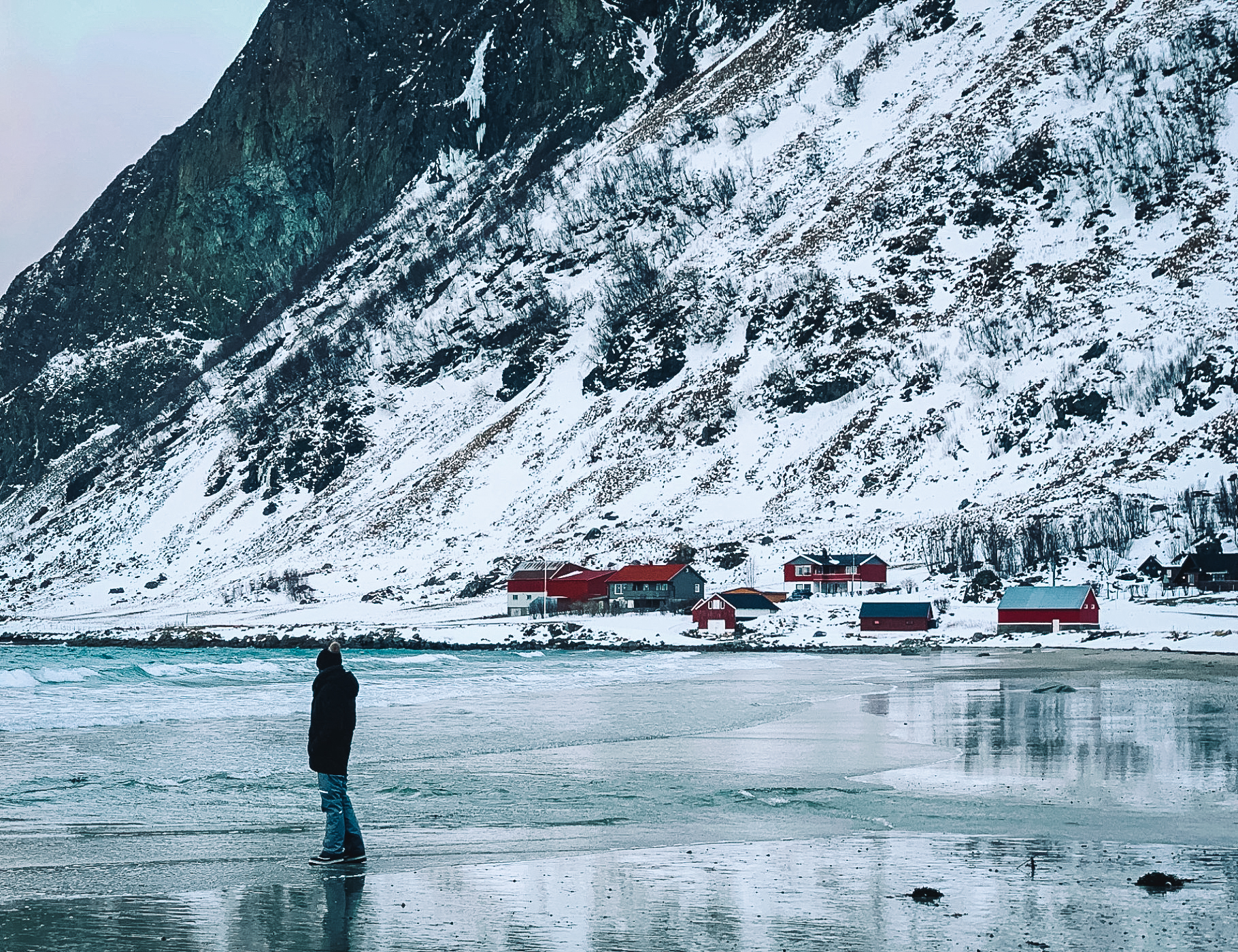 Man standing on a snowy beach in a fjord in Norway near Tromsø