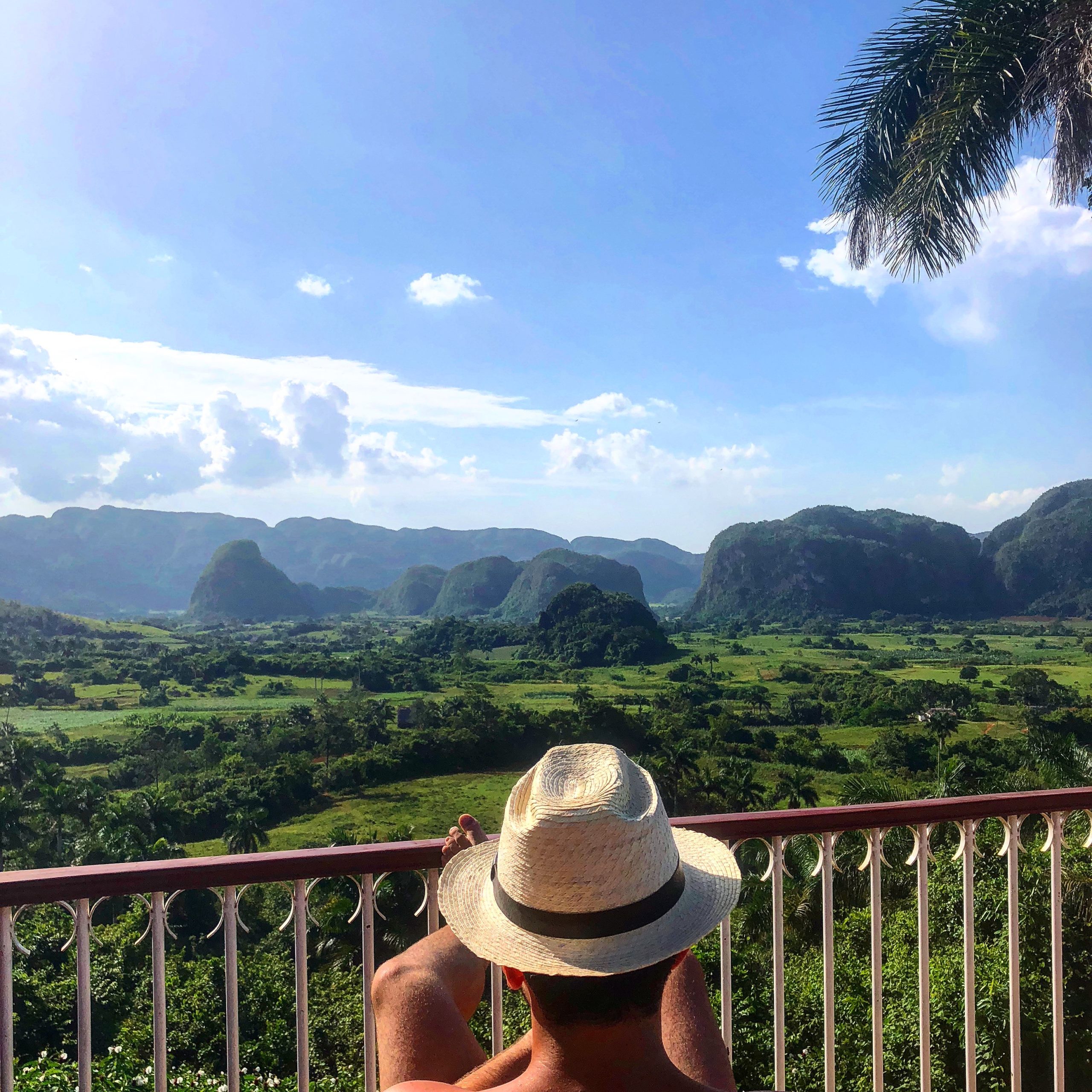 Man sitting on a chair overlooking Mogotes in Viñales in Cuba