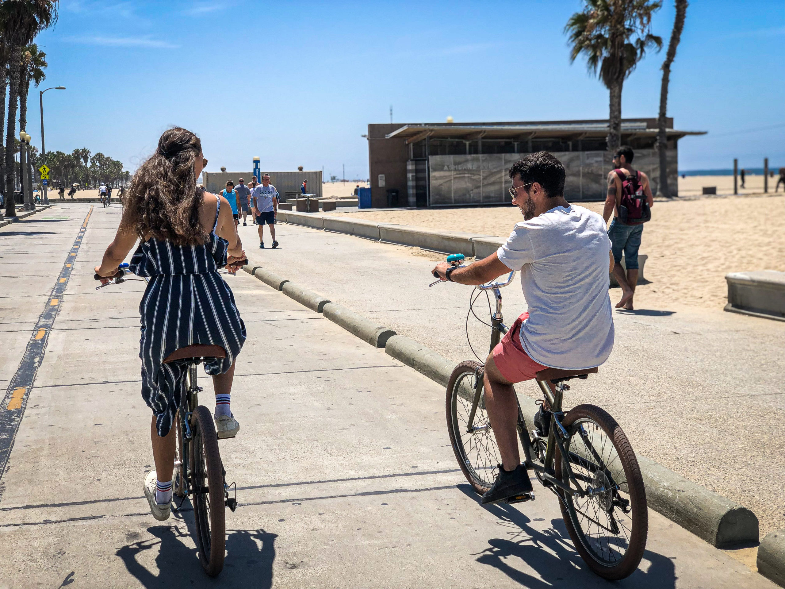 A man and a woman biking in Venice Beach