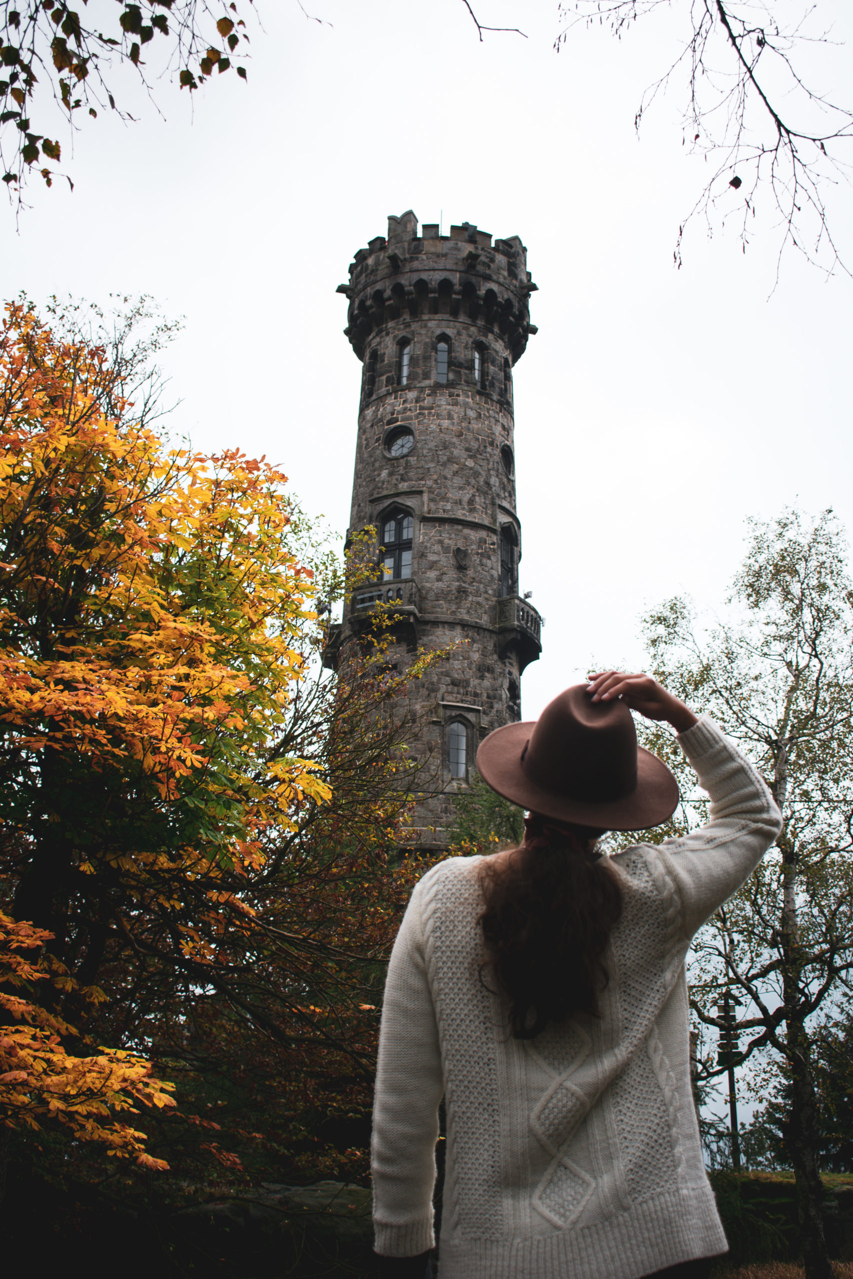 Woman standing in front of an old tower in Bohemian Switzerland National Park in Czech Republic